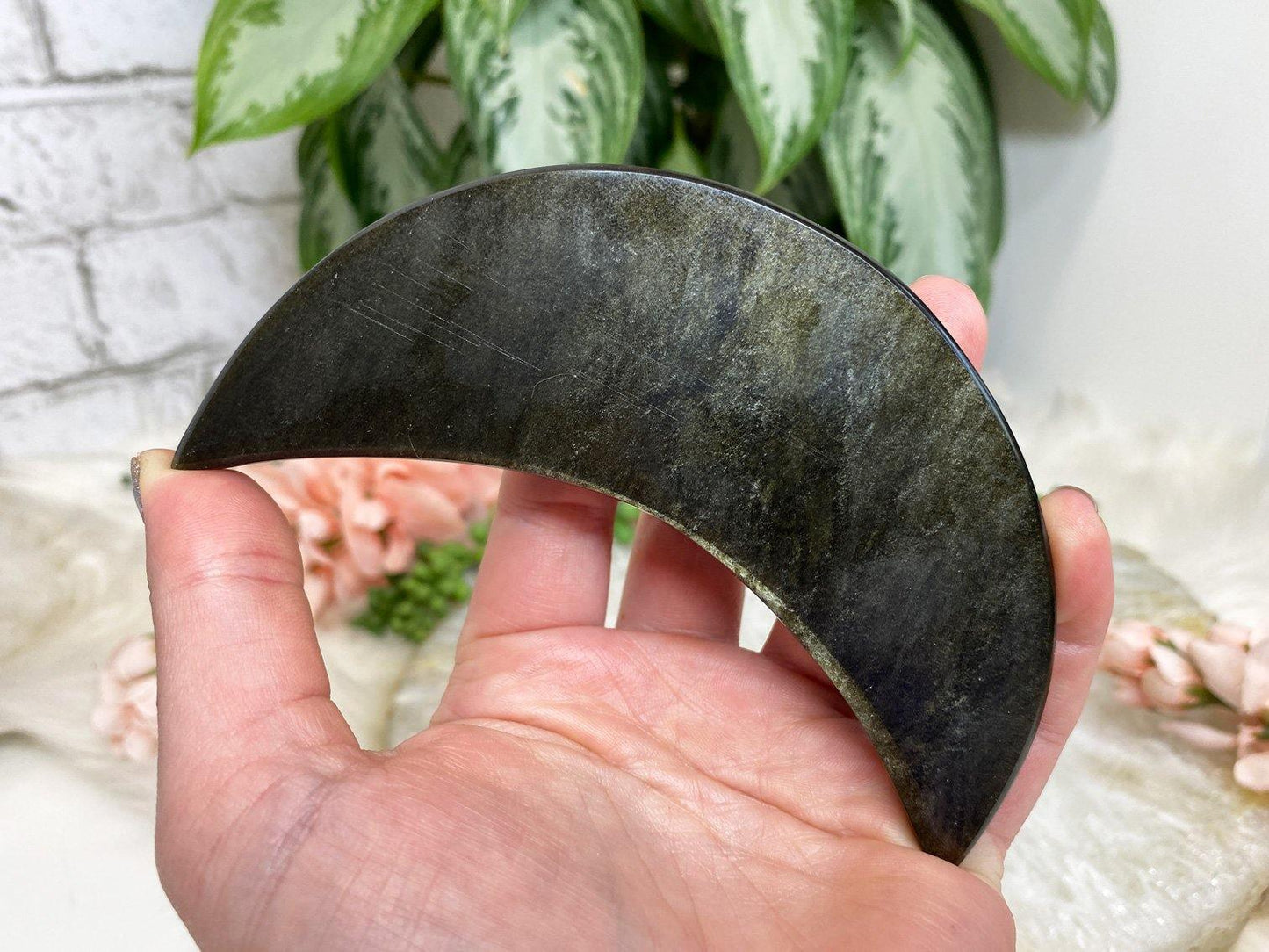 gold sheen obsidian stone carved moon crystal in hand